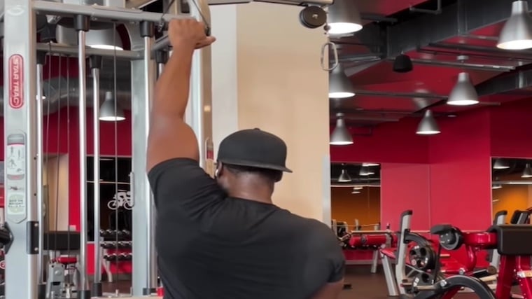 Coach Lee Boyce in gym performing back exercise.